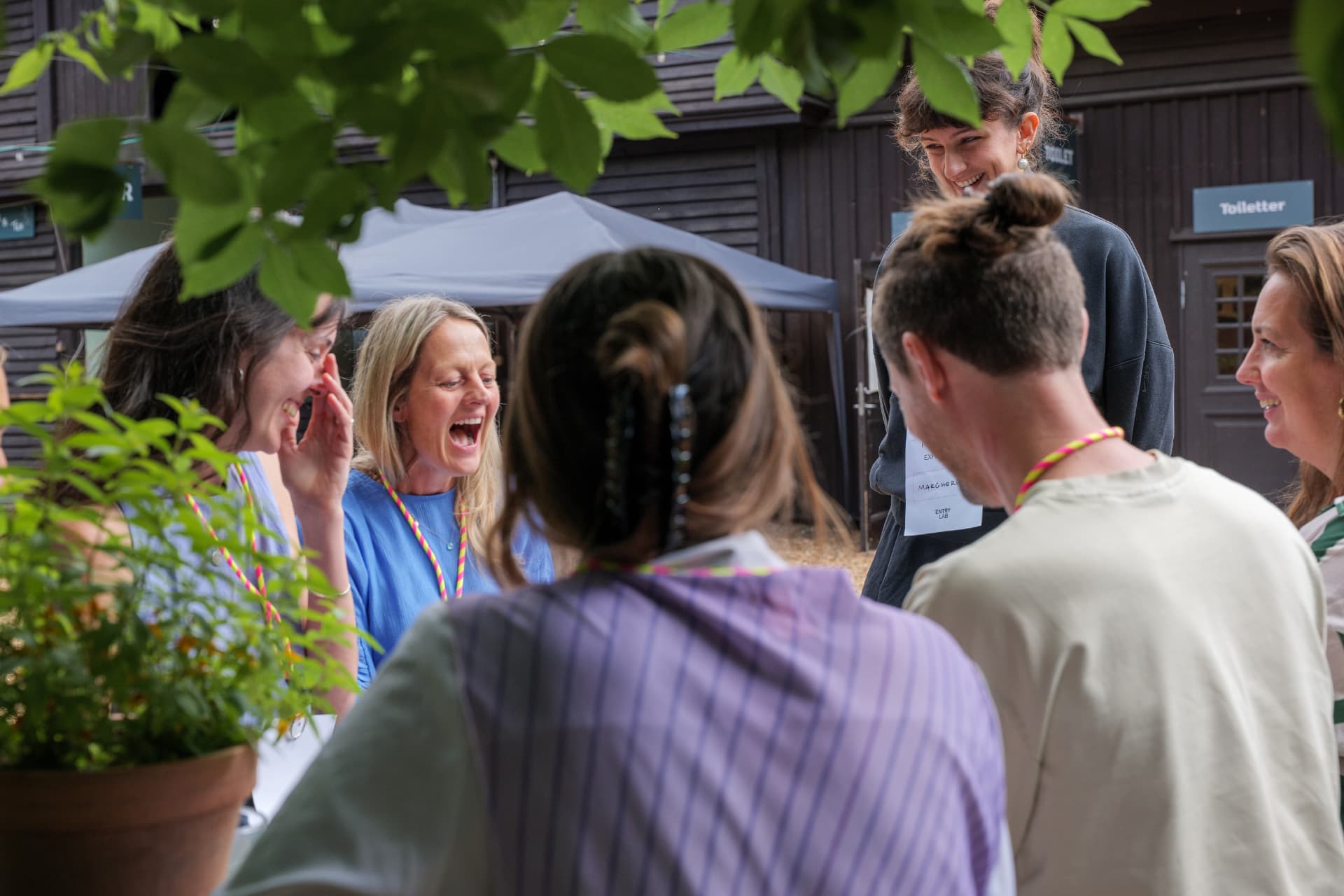A small group of participants laughing together outdoors during a break at the festival